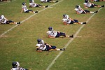 Free Stock Photo: High school football players doin warm up exercises on a field