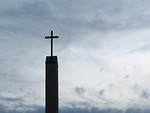 Free Stock Photo: A cross before a cloudy sunset sky.