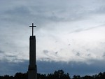Free Stock Photo: A cross before a cloudy sunset sky.