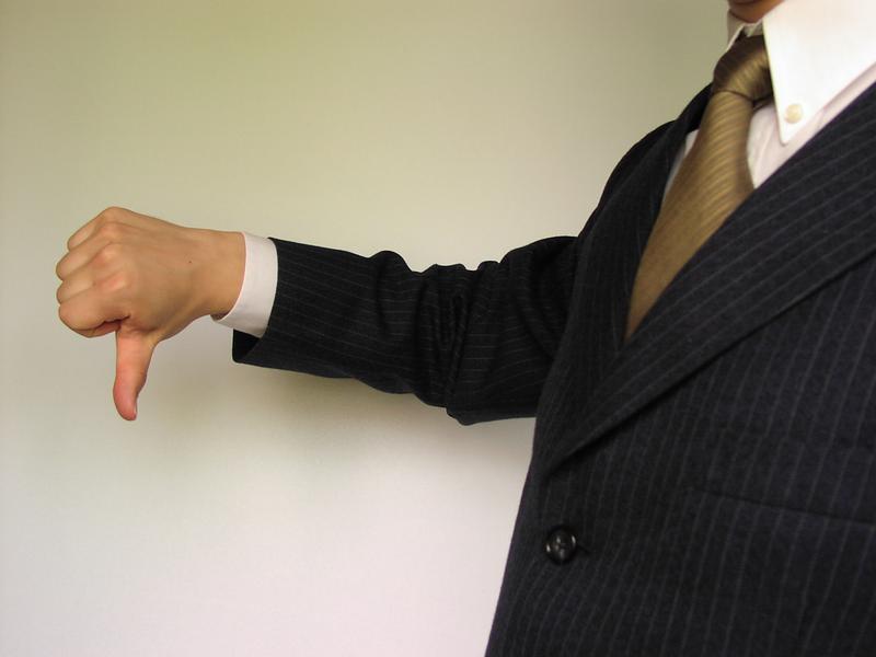 Business man in a suit and tie giving the thumbs down symbol. : Free Stock Photos
